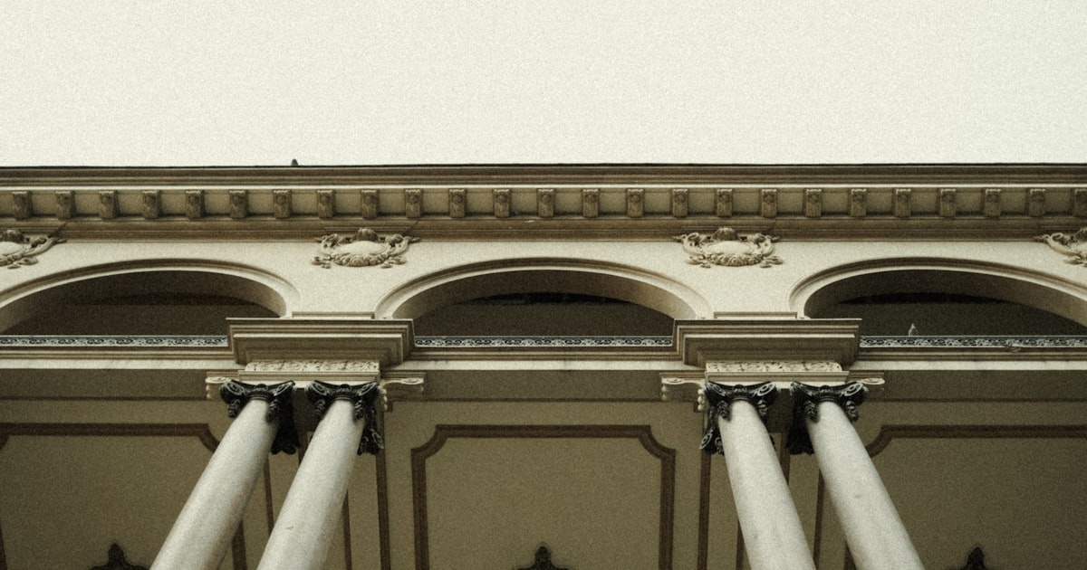 A building with columns and a clock on the top of it