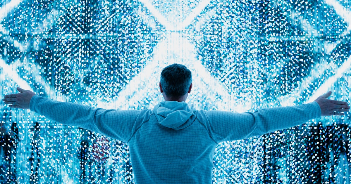A man standing in front of a large display of numbers
