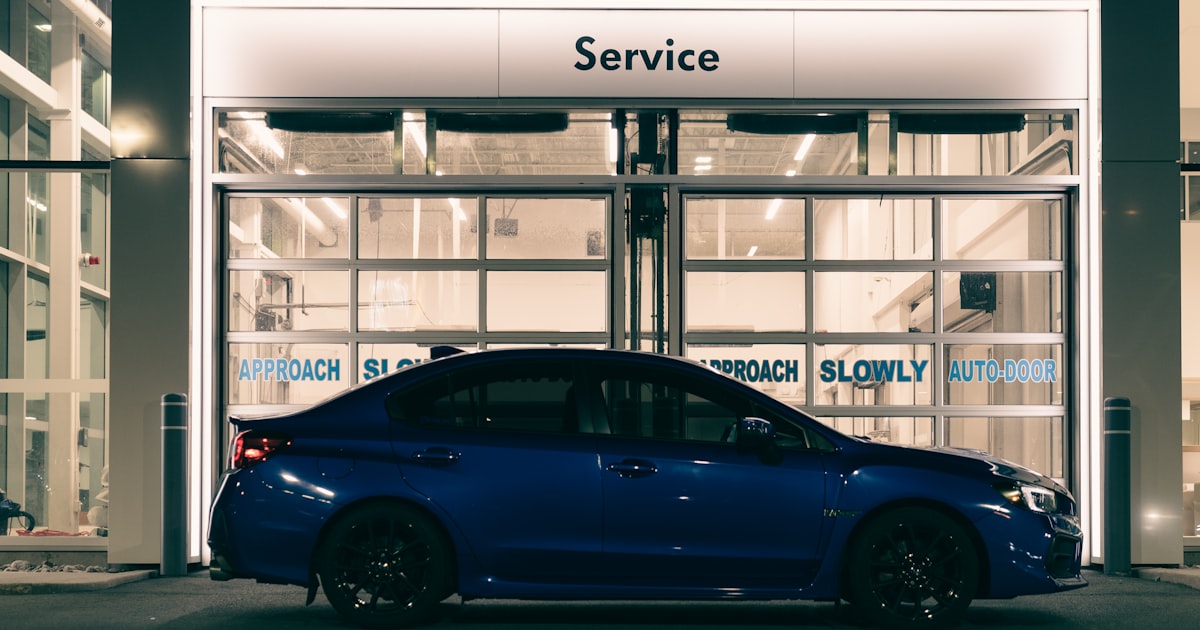 A blue car parked in front of a building
