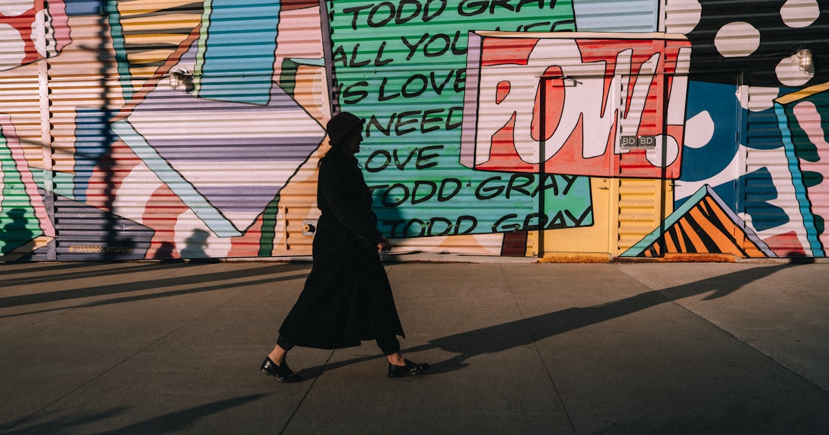 Person walks past colorful graffiti art wall