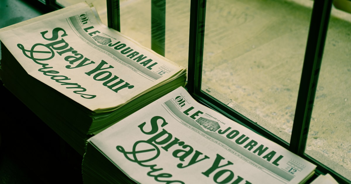 a stack of newspapers sitting on top of a wooden floor