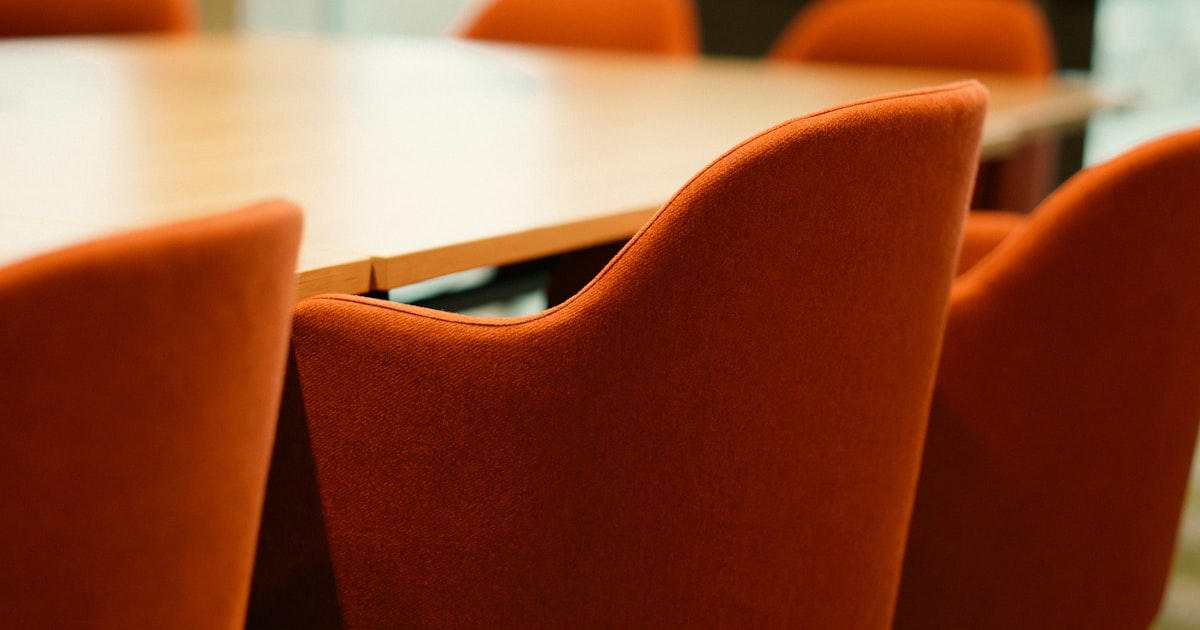 Orange chairs around a wooden conference table