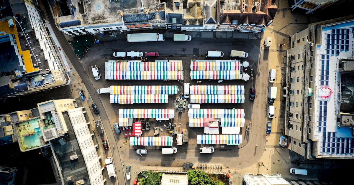 aerial photography of city with high-rise buildings and different vehicles on road during daytime