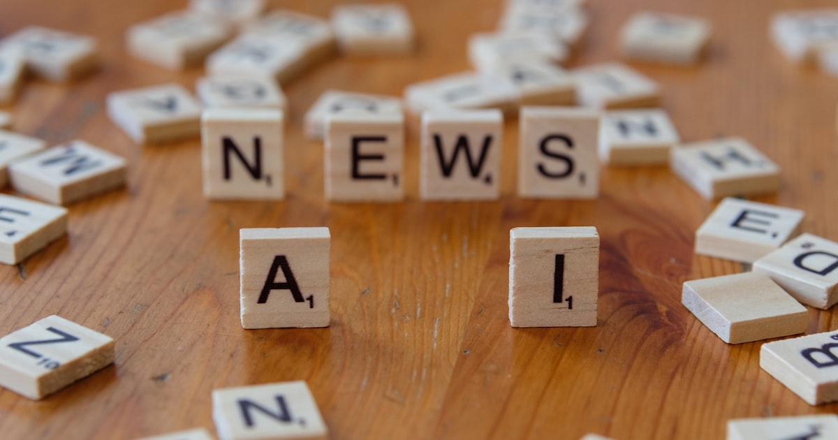 A wooden table topped with scrabble tiles spelling news and mail