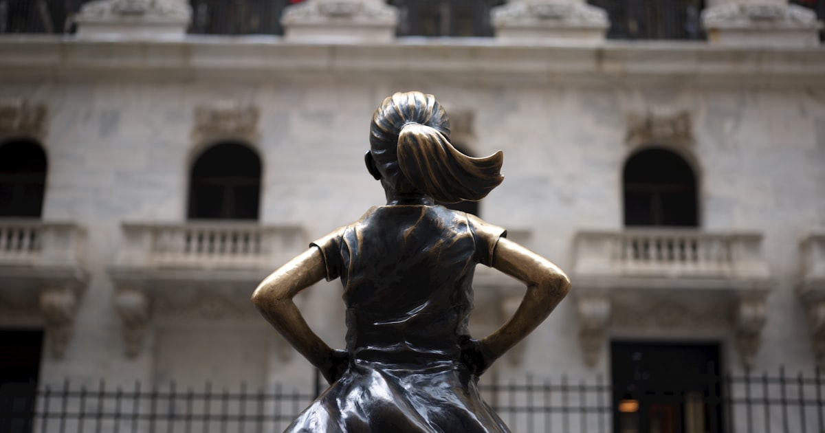 Fearless girl statue facing new york stock exchange building.