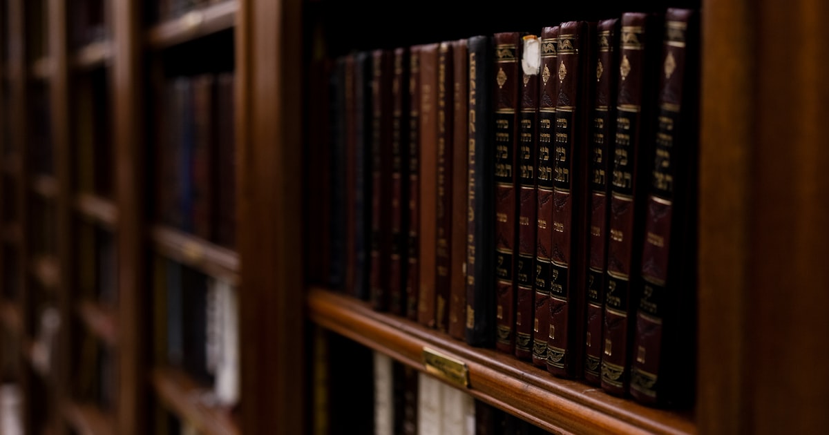 close-up photo of books in brown wooden shelf