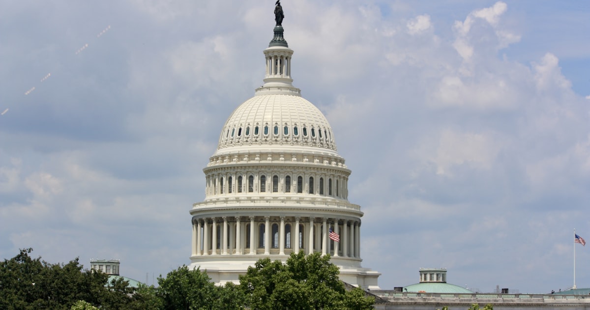 United states capitol building dome against a cloudy sky.