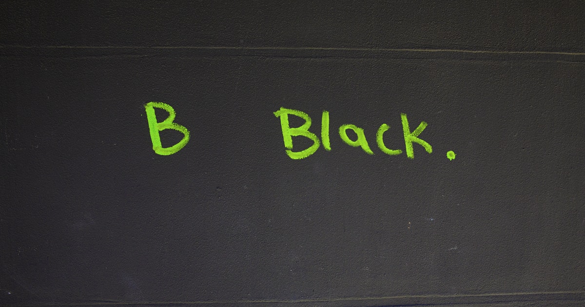 Green letters spelling "b black." on dark background