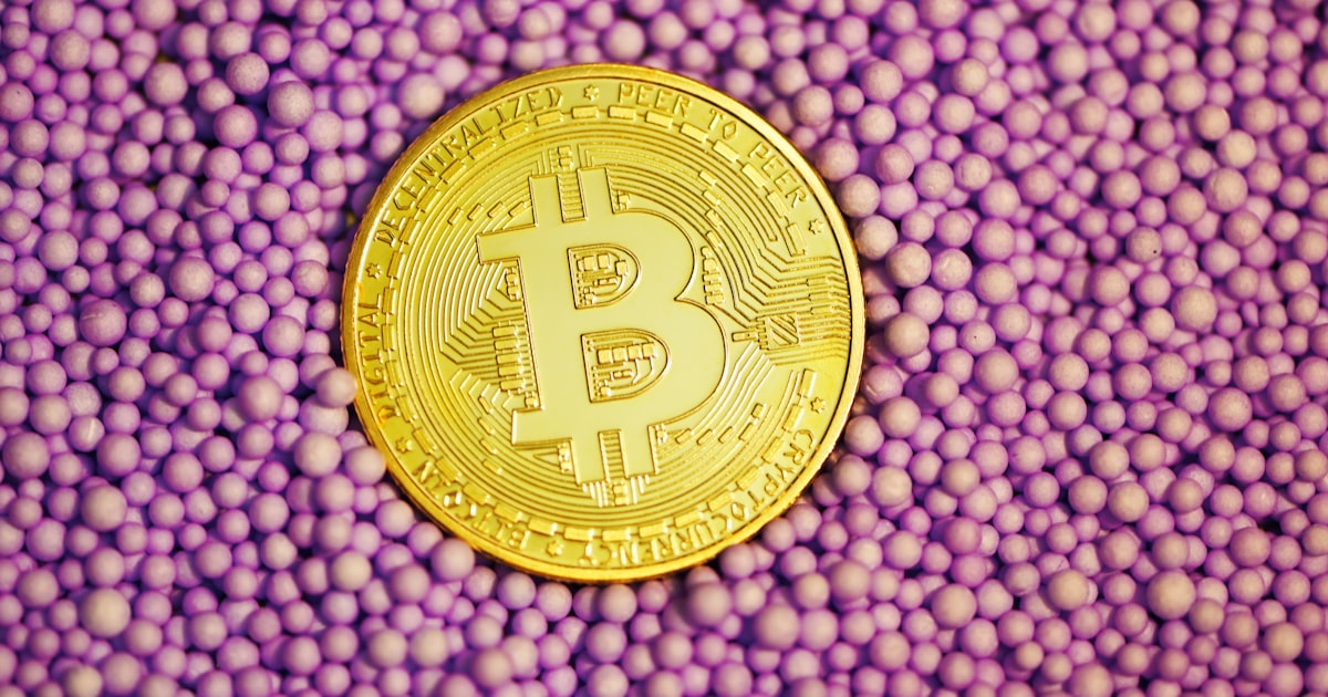 gold round coin on blue and white textile