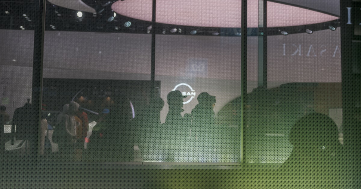 A group of people standing in front of a window