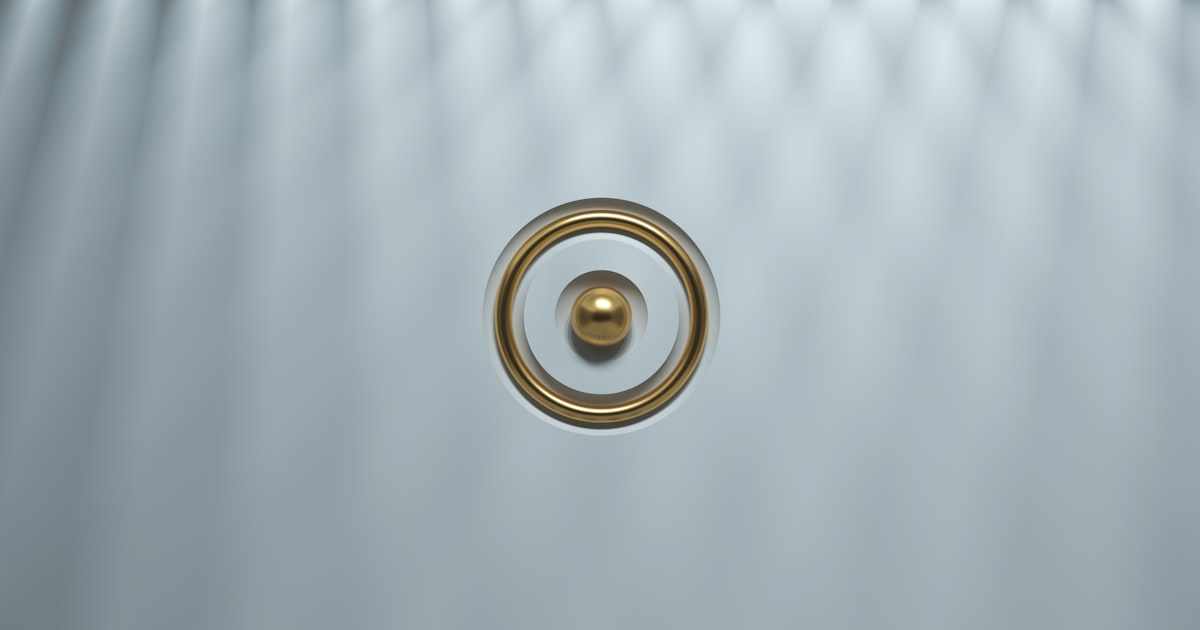 a gold ring on a white surface