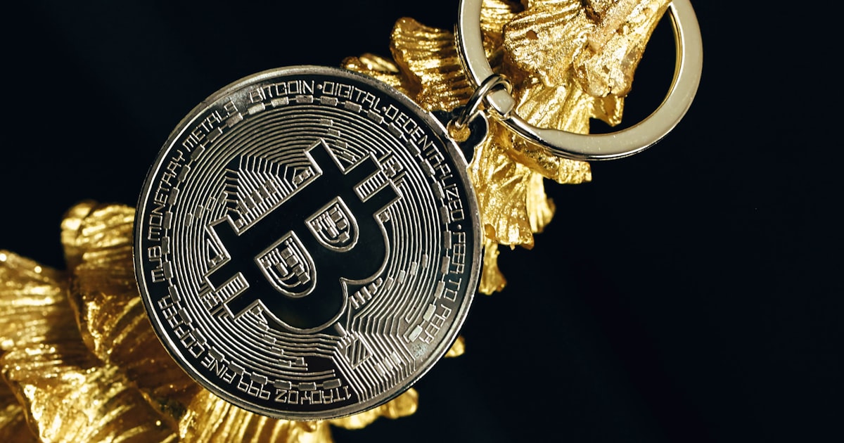 a golden keychain with a bitcoin on it