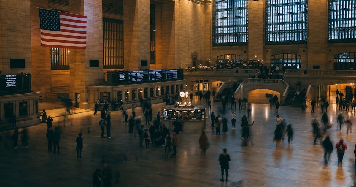 a group of people walking around a train station