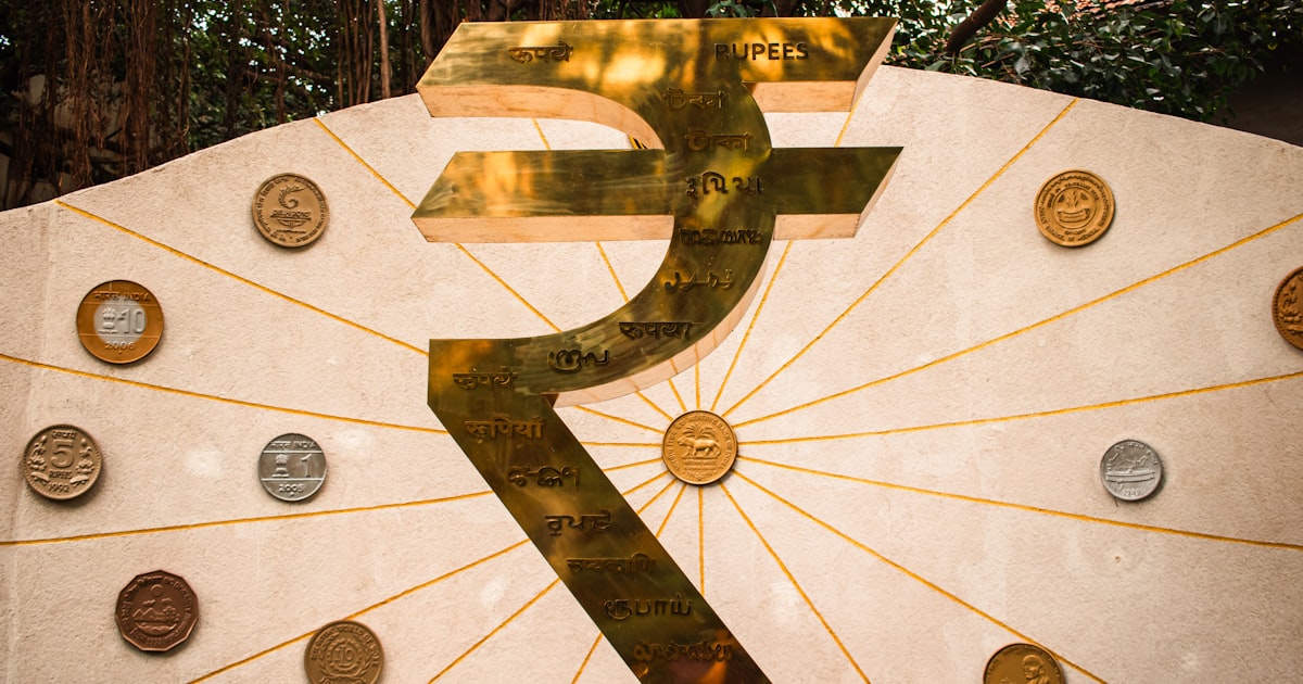 The image features a large indian rupee symbol.