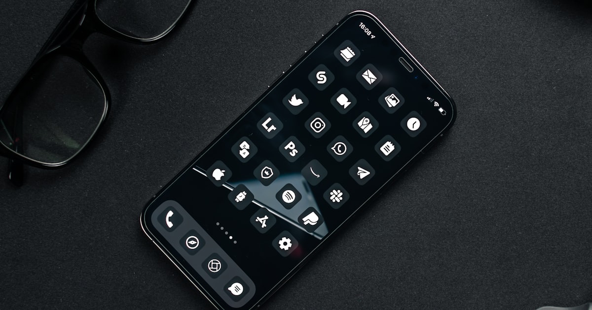 black remote control beside black framed eyeglasses