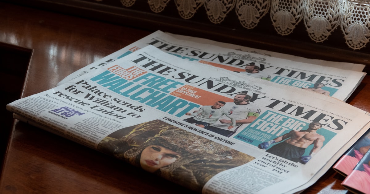 a bunch of newspapers sitting on top of a wooden table