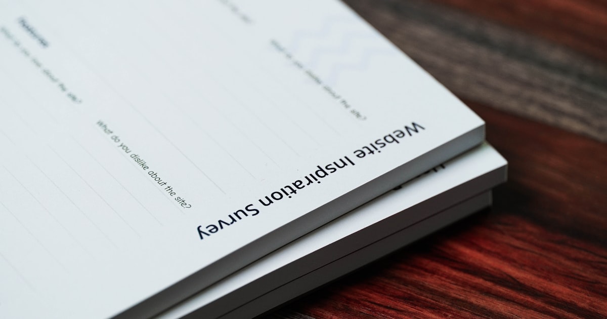 a stack of papers sitting on top of a wooden table