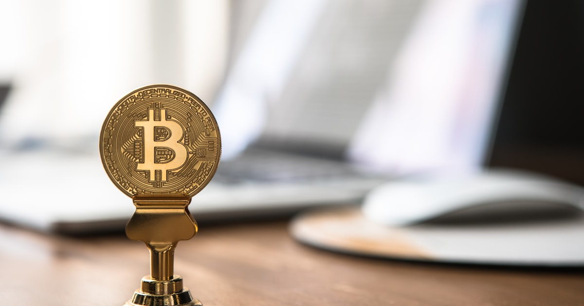 round gold-colored bitcoin on table