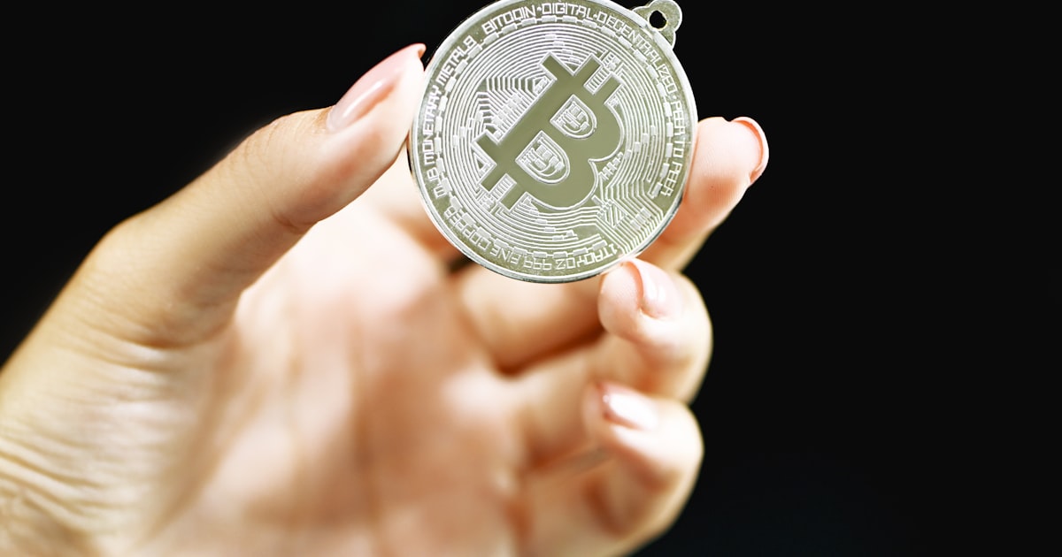 person holding silver round coin