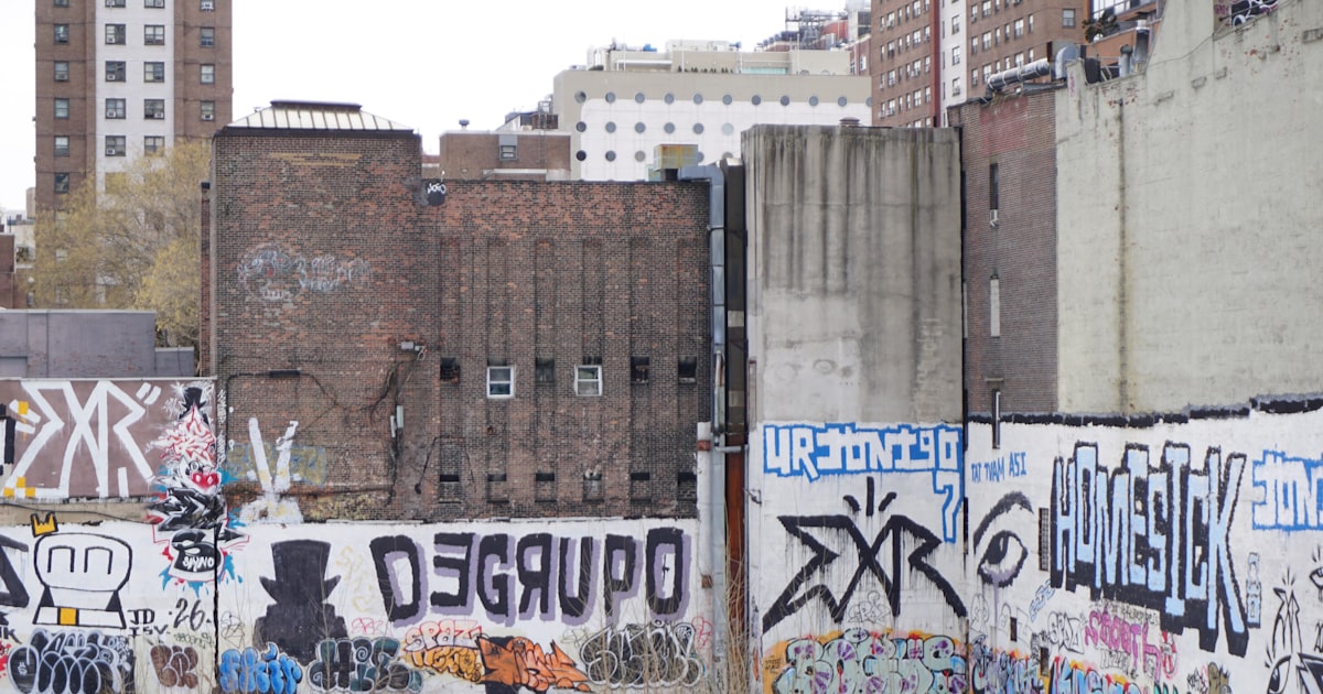 Graffiti art covers walls in an urban alleyway.