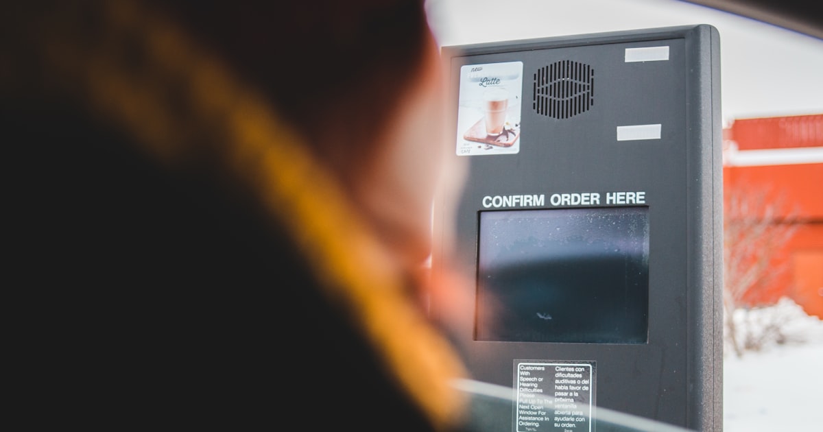 person inside car near digital order receiver