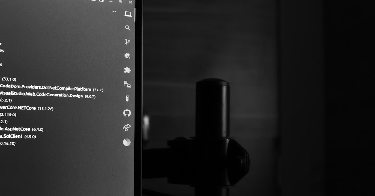 Computer monitor displaying code in a dark room.