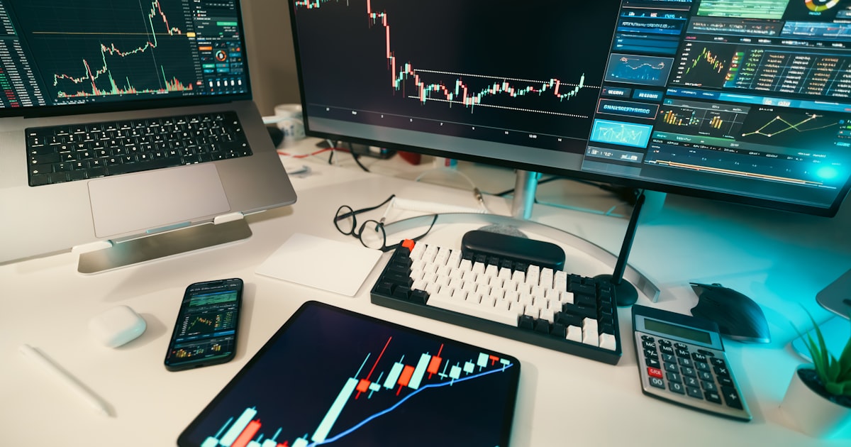 Stock charts are displayed on multiple screens.