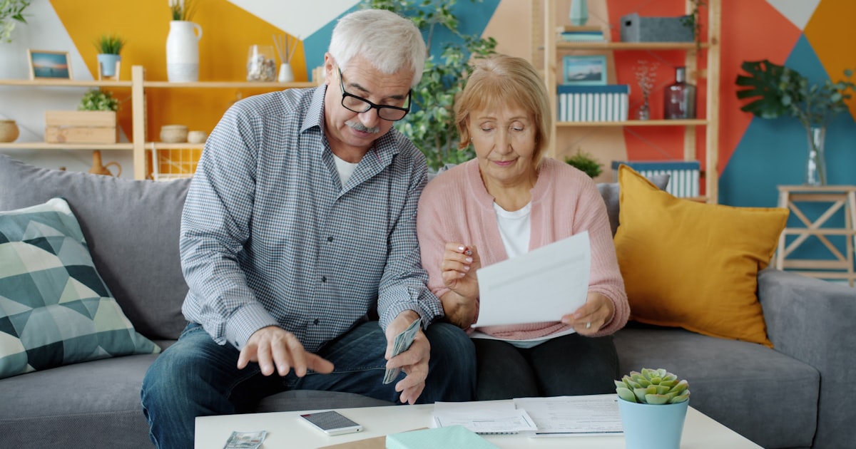 Elderly couple reviewing documents at home