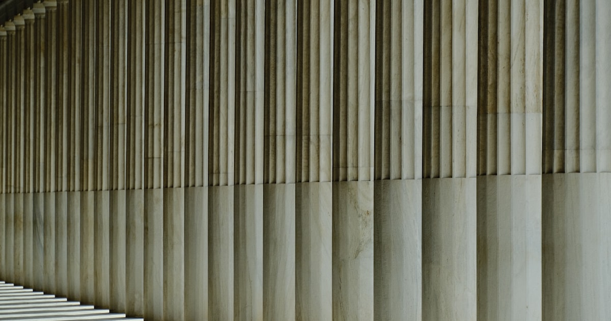 a long row of white columns next to a building