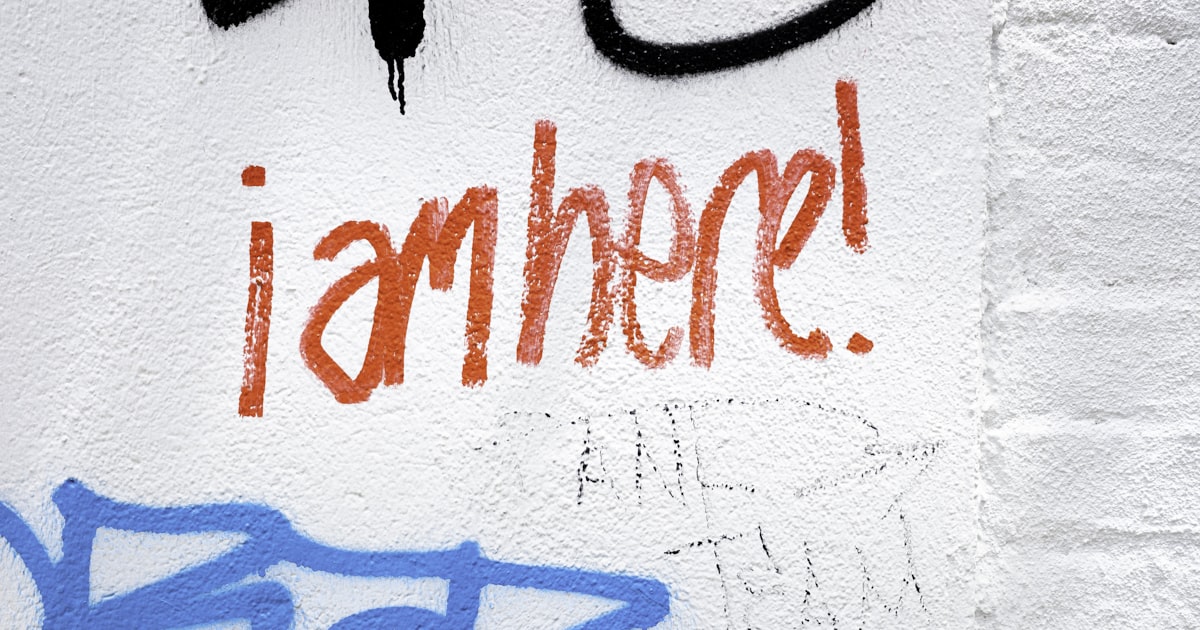 Red graffiti text says "iamhere!" on wall