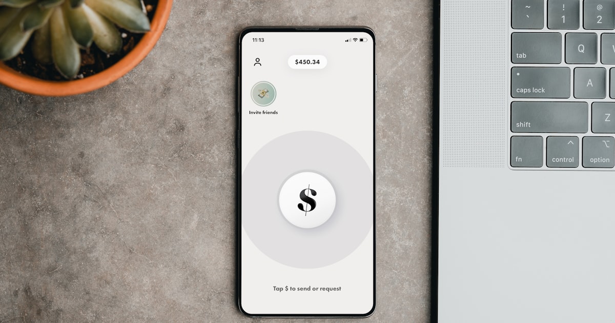 a cell phone sitting on top of a table next to a laptop