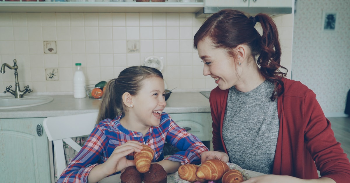 Two girls enjoying breakfast together at the table.