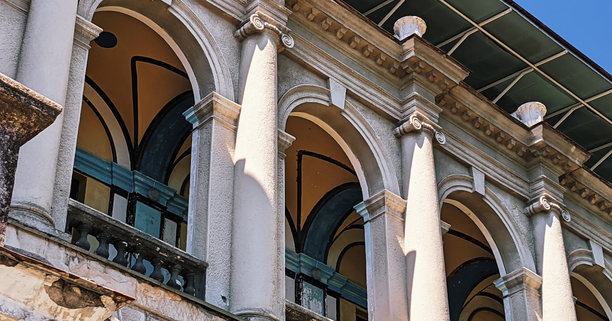 a building with columns and a clock on the front of it