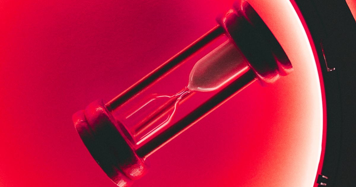 clear hour glass with red background