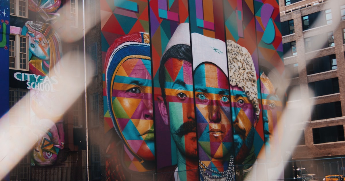 five faces of men and women painting on wall