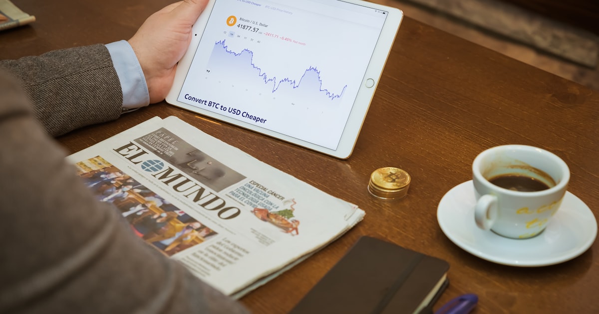 a person sitting at a table with a tablet and a cup of coffee