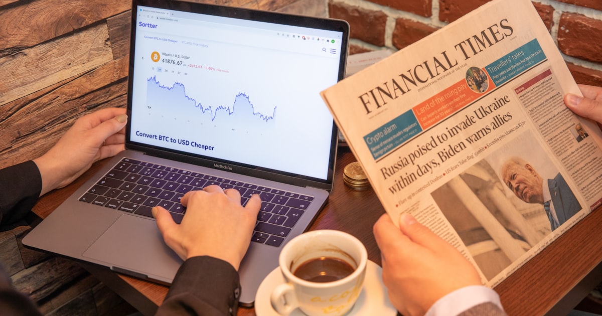 a person sitting at a table with a laptop and a cup of coffee
