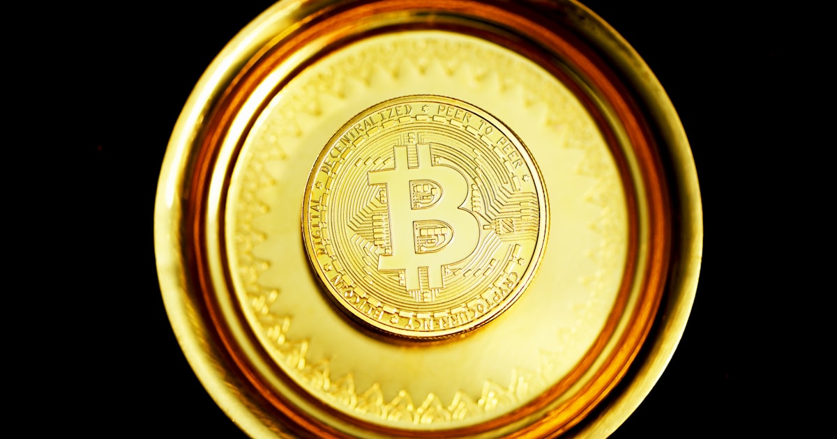 gold round coin on black surface