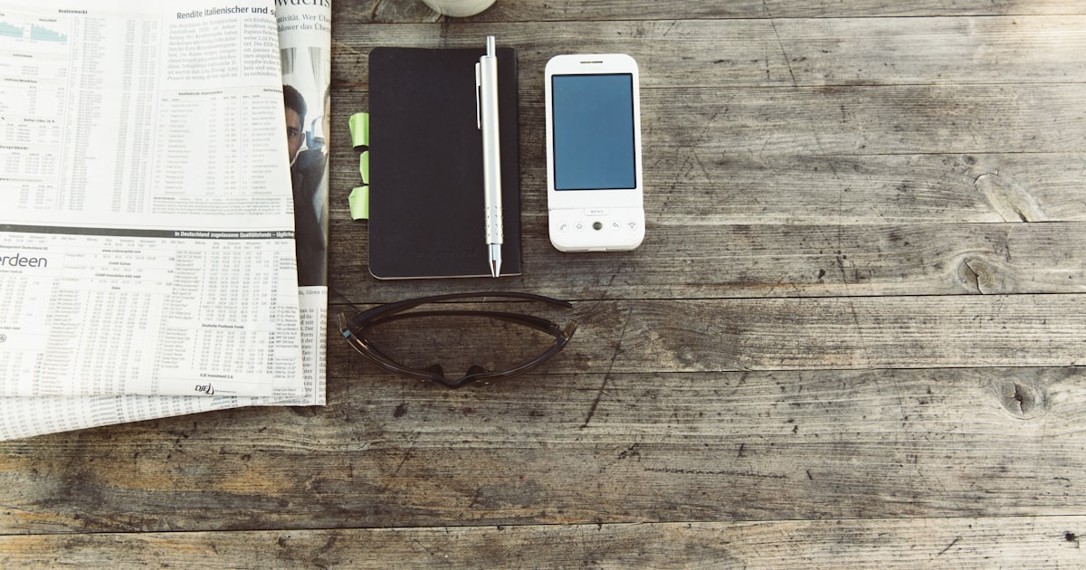 pen beside mobile phone on wooden surface