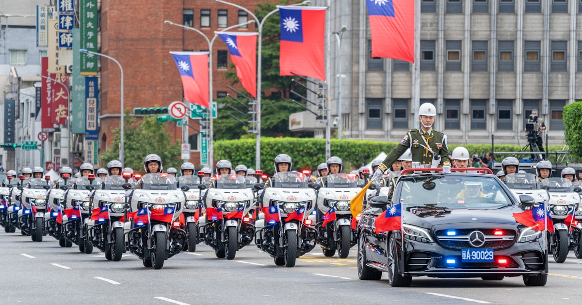 A parade with a car driving down a street