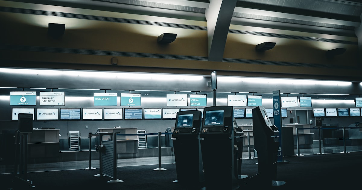 Empty airport check-in counters with glowing screens