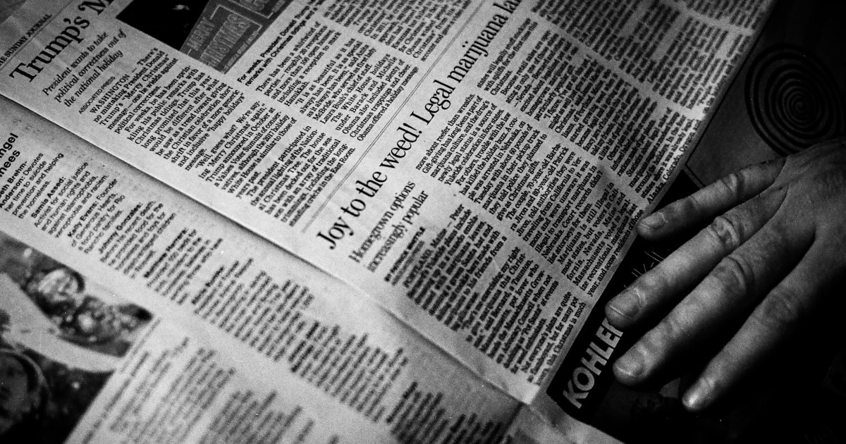 person's right hand near newspaper