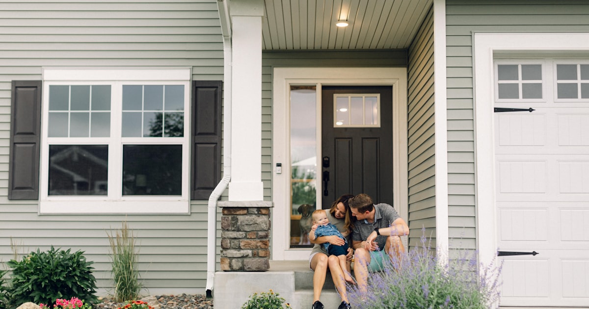 a couple of people that are sitting in front of a house