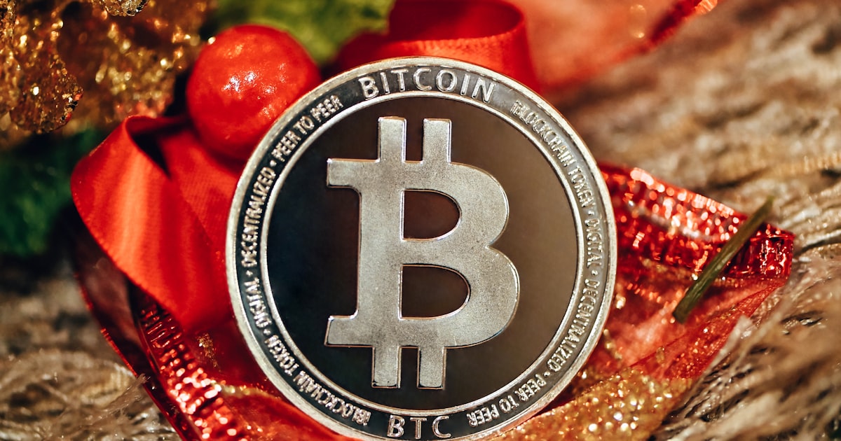 a bitcoin coin sitting on top of a red ribbon