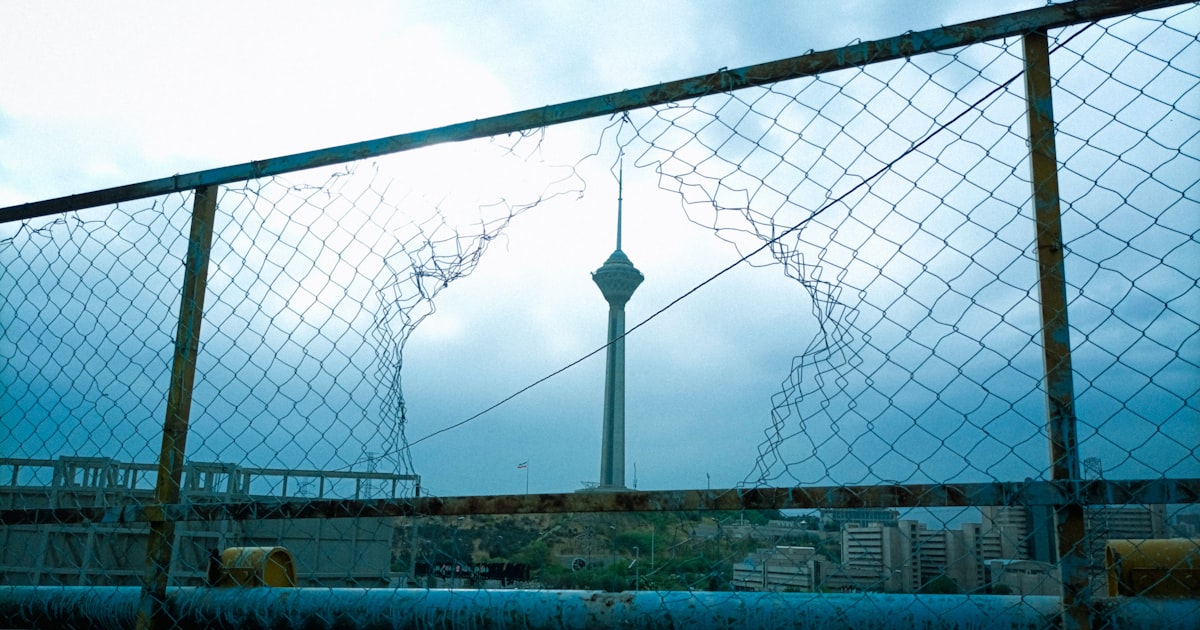 a fence with a tower in the background
