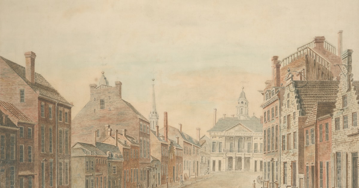 Historic street scene with brick buildings and a central structure.