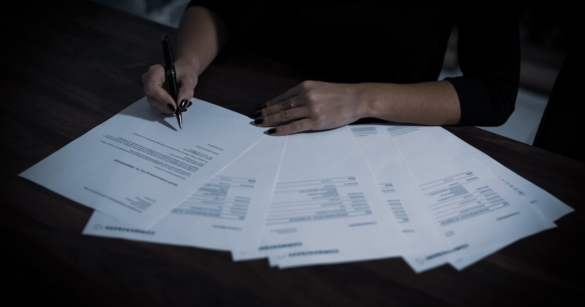 a woman sitting at a table with lots of papers
