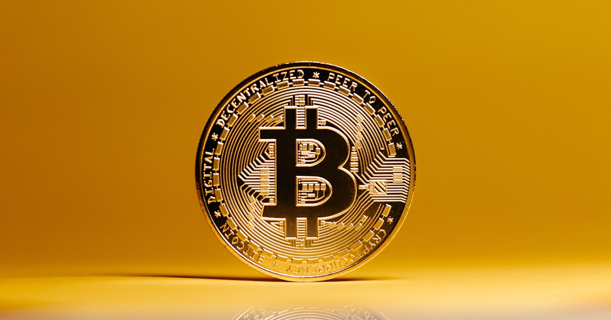 a bit coin sitting on top of a reflective surface