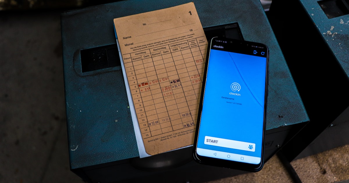 a cell phone sitting on top of a table next to a piece of paper