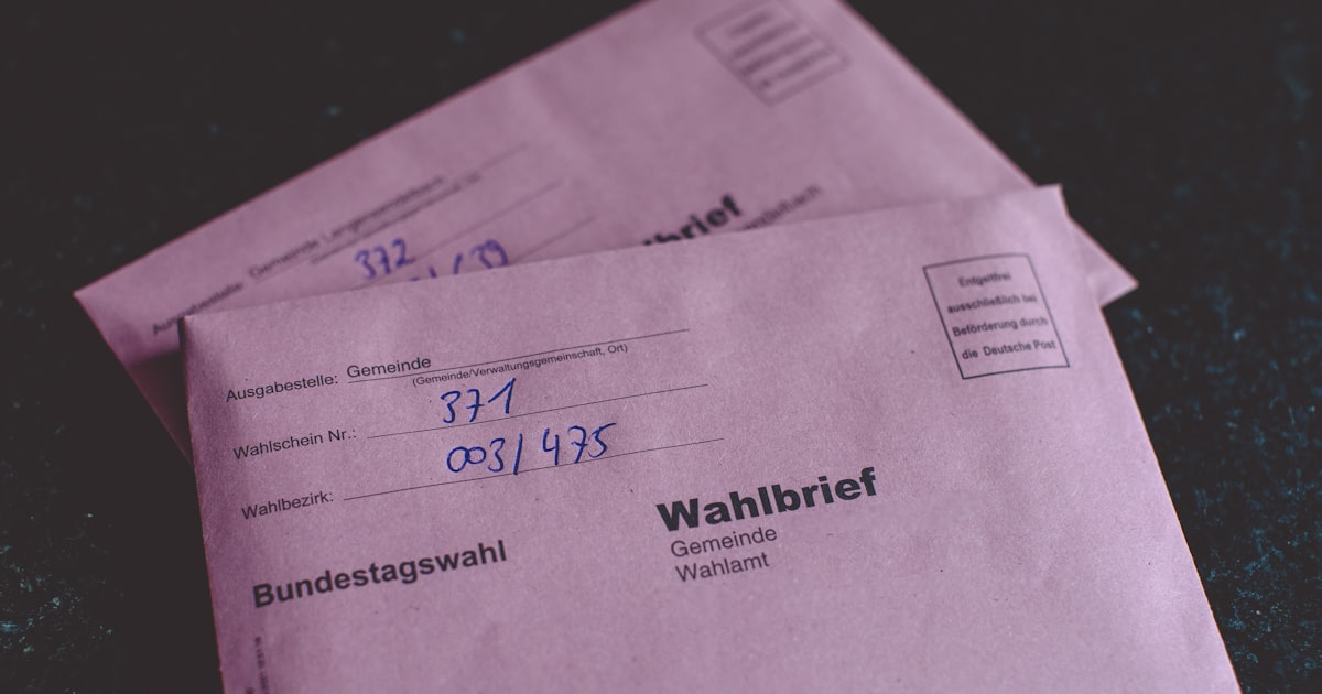 two pink envelopes sitting on top of a table